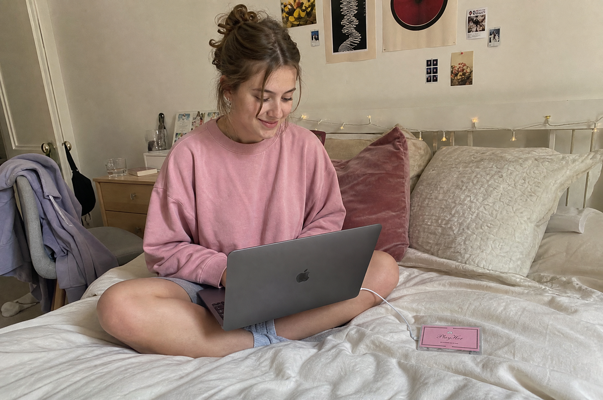 Playing PlayHer on a laptop in bed